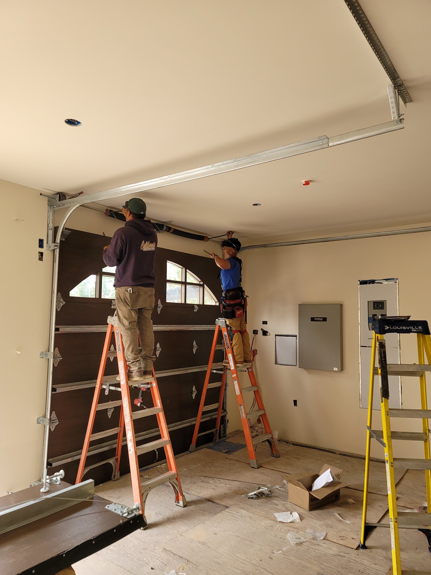 Technicians installing a residential garage door